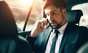A businessman in a car, talking on cellphone